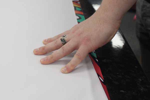 hemming banner, staff folding over the edge of the banners to secure the edge from not ripping